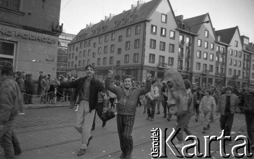 7.02.1989, Wrocław, Polska.
Happening Pomarańczowej Alternatywy na ulicy Świdnickiej - Śledzik na Świdnickiej czyli Zakończenie Karnawału. Pochód tłumu. Na pierwszym planie uczestnik pokazujący znak zwycięstwa.
Fot. Mieczysław Michalak, zbiory Ośrodka KARTA