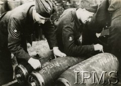 Maj 1944, Coolham, Anglia, Wielka Brytania.
Polscy mechanicy wypisują hasła na 500-funtowych bombach podwieszanych pod skrzydła Mustangów. Na jednej z bomb napis: 