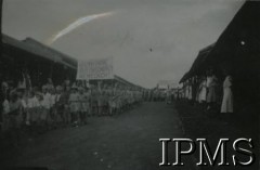 1943-1947, prawdopodobnie Valivade, Indie.
Uroczystość w osiedlu dla polskich uchodźców. W pochodzie uczestniczą dzieci, harcerze niosą transparent o treści: 