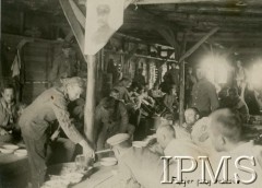 Lipiec - grudzień 1917, Szczypiorno k. Kalisza.
Żołnierze I i II Brygady Legionów, internowani w obozie jenieckim po odmowie przysięgi na wierność Niemcom. Jeńcy we wnętrzu baraku, kwatermistrz wydaje posiłek - podpis: 