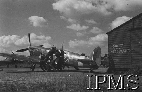 24.06.1943, Northolt, Anglia, Wielka Brytania.
Lotnisko 303 Dywizjonu Myśliwskiego - obsługa naziemna przekołowuje samolot. Napis na ścianie budynku: 