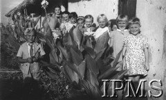 1942-1943, Tengeru, Tanganika.Osiedle dla polskich uchodźców, dzieci w towarzystwie swojej opiekunki.[Polscy uchodźcy w 1942 roku trafili do Iranu wraz z nowoutworzonym Wojskiem Polskim pod dowództwem generała Władysława Andersa (w dwóch rzutach ewakuacyjnych z ZSRR w marcu i sierpniu). W sumie oprócz wojska dotarło tam 38 tys. Polaków, z czego ponad połowę stanowiły dzieci i młodzież. Ok. 20 tys. znalazło się następnie w Afryce, polskie osiedla znajdowały się przede wszystkim w: Ugandzie, Kenii, Tanganice, Rodezji Północnej i Rodezji Południowej, Związku Południowej Afryki. Tengeru było największym polskim osiedlem uchodźczym w Afryce Wschodniej].Fot. NN, Instytut Polski i Muzeum im. gen. Sikorskiego w Londynie [album 212 - Osiedla polskie w Afryce Wschodniej].