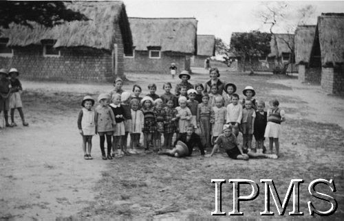 1942-1943, Ifunda, Tanganika.
Grupa dzieci w towarzystwie opiekunki.
[Polscy uchodźcy w 1942 roku trafili do Iranu wraz z nowoutworzonym Wojskiem Polskim pod dowództwem generała Władysława Andersa (w dwóch rzutach ewakuacyjnych z ZSRR w marcu i sierpniu). W sumie oprócz wojska dotarło tam 38 tys. Polaków, z czego ponad połowę stanowiły dzieci i młodzież. Ok. 20 tys. znalazło się następnie w Afryce, polskie osiedla znajdowały się przede wszystkim w: Ugandzie, Kenii, Tanganice, Rodezji Północnej i Rodezji Południowej, Związku Południowej Afryki.]
Fot. NN, Instytut Polski i Muzeum im. gen. Sikorskiego w Londynie [album 212 - Osiedla polskie w Afryce Wschodniej].