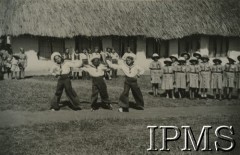 1943, Kondoa, Tanganika.
Osiedle dla polskich uchodźców, widoczni chłopcy tańczący w strojach marynarskich, po prawej harcerki. Podpis oryginalny: 