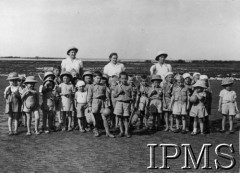 1942-1946, Balachadi k. Jamnagar, Indie.Osiedle dla dzieci polskich ewakuowanych ze Związku Radzieckiego, na zdjęciu grupa dzieci ze swoimi opiekunkami.[Polscy uchodźcy w 1942 roku trafili do Iranu wraz z nowoutworzonym Wojskiem Polskim pod dowództwem generała Władysława Andersa (w dwóch rzutach ewakuacyjnych z ZSRR w marcu i sierpniu). W sumie oprócz wojska dotarło tam 38 tys. Polaków, z czego ponad połowę stanowiły dzieci i młodzież. Około 10 tys. z nich trafiła potem do Indii. Osiedle w Balachadi było pierwszym w Indiach stałym polskim osiedlem uchodźczym].Fot. NN, Instytut Polski i Muzeum im. gen. Sikorskiego w Londynie [szuflada 45 - Polacy na emigracji].