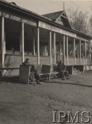 Lata 20., ZSRR.
Dwaj mężczyźni siedzący na ławkach przed 