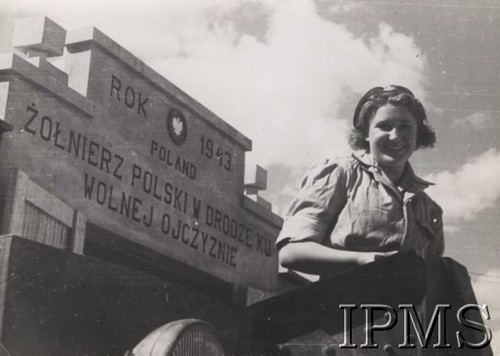 1943, brak miejsca.
Uśmiechnięta dziewczyna w mundurze, w tle napis: 