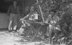 Maj 1944, Cassino, Włochy.
Bitwa pod Monte Cassino, oficerowie 2 Korpusu siedzący przy składanym stoliku.
Fot. T. Szumański, Instytut Polski im. Gen. Sikorskiego w Londynie [album negatywowy nr 105]

