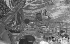 Maj 1944, Cassino, Włochy.
Bitwa pod Monte Cassino, czołgiści spożywający posiłek obok swojego czołgu, pod siatką maskującą.
Fot. T. Szumański, Instytut Polski im. Gen. Sikorskiego w Londynie [album negatywowy nr 105]

