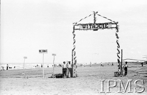 Kwiecień 1942, Pahlewi, Iran (Persja).
Obóz dla polskich uchodźców. Brama wjazdowa do rejonów. Wjeżdżających czy wchodzących pozdrawia napis: 