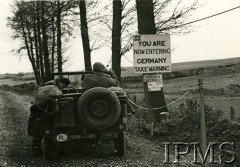 1944-1945, III Rzesza Niemiecka.
I Dywizja Pancerna. Żołnierze w samochodzie terenowym na drodze, na drzewie tablica z napisem: 