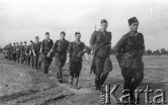 1944, Wileńszczyzna.
Żołnierze 3 plut. 1 komp. 5 Bryg. Part. w marszu gęsiego. Od czoła: dowódca plutonu ppor. Marian Pluciński 