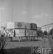 1972, Kraków, Polska.
Skwer na nowohuckim osiedlu. Na rusztowaniach wiszą plakaty z propagandowymi hasłami 