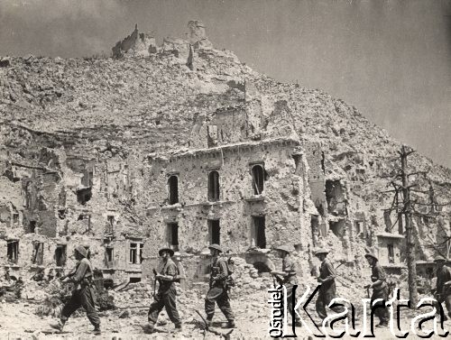Maj 1944, Cassino, Włochy.
Bitwa pod Monte Cassino. Żołnierze angielscy z batalionów 1/6 East Surreys przechodzą ulicą miasteczka, w tle ruiny na Wzgórzu Zamkowym.
Fot. NN, zbiory Instytutu Józefa Piłsudskiego w Londynie
