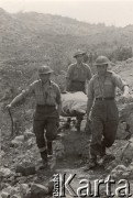 Maj 1944, Cassino, Włochy.
Bitwa pod Monte Cassino. Żołnierze 2 Korpusu niosący dowódcę na noszach. Podpis: 