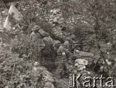 Maj 1944, Cassino, Włochy.
Bitwa pod Monte Cassino. Sanitariusze z flagą Czerwonego Krzyża znoszący rannego żołnierza z pola walki.
Fot. NN, zbiory Instytutu Józefa Piłsudskiego w Londynie
