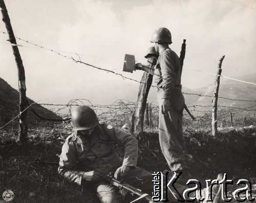 Wiosna 1944, rejon Monte Cassino, Włochy.
Bitwa pod Monte Cassino. Dwaj amerykańscy żołnierze przy ogrodzeniu z drutu kolczastego, na którym wisi kartka: 
