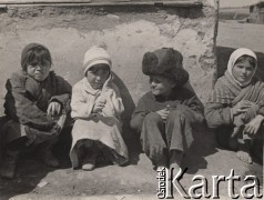 1942, Wrewskoje, Uzbekistan, ZSRR.
Obóz dla ludności cywilnej przy powstającej Armii Andersa, dzieci siedzące przy ścianie budynku.
Fot. NN, zbiory Instytutu Józefa Piłsudskiego w Londynie