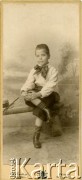 1889-1896, Düren, Niemcy.
Portret chłopca w odświętnym stroju - białej koszuli w paski, kokardzie w grochy, skarpetkach w paski. Zdjęcie wykonane w atelier fotograficznym 