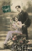 1907, Francja.
Portret zakochanej pary - kobiety w fioletowej sukni i mężczyzny w garniturze. Kobieta trzyma w ręce rybę, obok na skale kosz z rybami, mężczyzna trzyma w dłoni wędkę. W lewym górnym rogu znaczek pocztowy o wartości 5C, z napisem 
