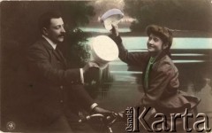 1906, Berlin, Niemcy.
Portret zakochanej pary - mężczyzny siedzącego na rowerze, w marynarce i białej koszuli oraz kobiety w żakiecie i zielonej bluzce. Para wymienia się pozdrowieniami, machając czapkami z daszkiem. Zdjęcie wykonane w atelier fotograficznym.
Fot. NN, zbiory Ośrodka KARTA, kolekcja Ryszarda Łopatki