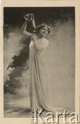 Pocz. XX wieku, Paryż, Francja.
Portret kobiety unoszącej dzban, w jasnej długiej sukni. Zdjęcie wykonane w atelier fotograficznym. Karta sygnowana nazwiskiem fotografa 