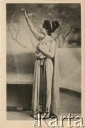 Pocz. XX wieku, Paryż, Francja.
Portret kobiety w jasnej sukni, przepasanej w pasie szarfą, z opaską we włosach. Zdjęcie wykonane w atelier fotograficznym. Karta sygnowana nazwiskiem fotografa 