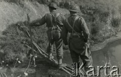 1944, wzgórze Monte Cassino, W≥ochy.
Dwóch żołnierzy piechoty 69 Pułku w trakcie  przechodzenia przez rzekę w rejonie Monte Cassino.
Fot. NN, zbiory Ośrodka KARTA, udostępniła Magdalena Braun