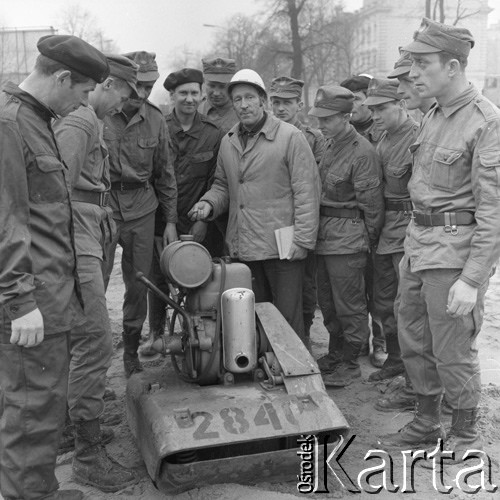 10.04.1973, Warszawa, Polska.
Budowa Trasy Łazienkowskiej. Inżynier pokazujący żołnierzom obsługę maszyny na Placu na Rozdrożu.
Fot. Lubomir T. Winnik, zbiory Ośrodka KARTA