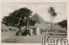 Egipt.
Grupa tubylców na cmentarzu, w głębi widoczna piramida.
Fot. NN, kolekcja Wacława Urbanowicza, zbiory Ośrodka KARTA