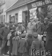 2.04.1950, Bojadła, woj. zielonogórskie, Polska.
Grupa mężczyzn i dzieci stoi przy stoisku z książkami obok Domu Ludowego. Zdjęcie wykonano w dniu otwarcia pierwszego w Polsce kina wiejskiego 