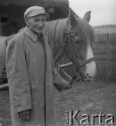 1961 lub 1965, Wigry, woj. białostockie, Polska.
Mężczyzna trzyma za uzdę swojego konia.
Fot. Jerzy Konrad Maciejewski, zbiory Ośrodka KARTA