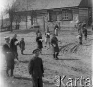 Prawdopodobnie lata 60., Polska.
Grupa dzieci stoi przed budynkiem. Na zdjęciu część z nich trzyma talerze z żywnością oraz kubki.
Fot. Jerzy Konrad Maciejewski, zbiory Ośrodka KARTA