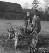 Prawdopodobnie lata 60., Polska.
Mężczyźni ładują na wóz świniaka.
Fot. Jerzy Konrad Maciejewski, zbiory Ośrodka KARTA