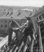 1948, Warszawa, Polska.
Cieśla Piotr Walencik (od lewej) i Edward Cichocki pracują przy ustawianiu dachu budowanego budynku.
Fot. Jerzy Konrad Maciejewski, zbiory Ośrodka KARTA