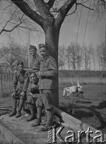 Wiosna 1940, La Maucarriere, Francja.
Żołnierze z 2. Dywizji Strzelców Pieszych odpoczywają pod drzewem. Z tyłu na huśtawce siedzi dziewczynka.
Fot. Jerzy Konrad Maciejewski, zbiory Ośrodka KARTA