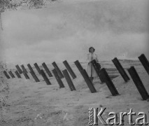 Czerwiec 1946, Dunkierka, Francja.
Kobieta stoi przy zaporach przeciwdesantowych, będących częścią umocnień Wału Atlantyckiego. Wał został zbudowany przez III Rzeszę Niemiecką na okupowanych terenach Zachodniej Europy.
Fot. Jerzy Konrad Maciejewski, zbiory Ośrodka KARTA