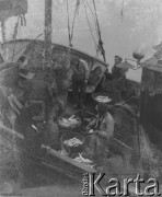 Czerwiec 1946, Dunkierka, Francja.
Rybacy na statku stoją przy koszach pełnych ryb.
Fot. Jerzy Konrad Maciejewski, zbiory Ośrodka KARTA