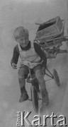 1942-1944, Münchenbuchsee, Szwajcaria.
Mały chłopiec siedzi na rowerze z przyczepką.
Fot. Jerzy Konrad Maciejewski, zbiory Ośrodka KARTA
