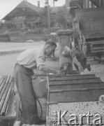1942-1944, Münchenbuchsee, Szwajcaria.
Mężczyzna podlewa wodą ze szlauchu wyroby znajdujące się w drewnianych skrzyniach.
Fot. Jerzy Konrad Maciejewski, zbiory Ośrodka KARTA

