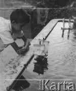 1942-1944, Münchenbuchsee, Szwajcaria.
Syn jednego z robotników włoskich puszcza statki na wodzie w studni.
Fot. Jerzy Konrad Maciejewski, zbiory Ośrodka KARTA
