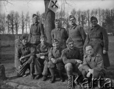 Wiosna 1940, La Maucarriere, Francja.
Żołnierze 2. Dywizji Strzelców Pieszych pozują do wspólnego zdjęcia. Jeden z nich trzyma flagę z krzyżem.
Fot. Jerzy Konrad Maciejewski, zbiory Ośrodka KARTA
