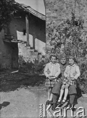 Wiosna 1940, La Maucarriere, Francja.
Żołnierz 2. Dywizji Strzelców Pieszych pozuje do zdjęcia z dwiema francuskimi dziewczynkami. Oryginalny podpis z tyłu zdjęcia: 