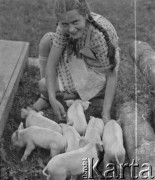 1940, Moospinte, Szwajcaria.
Córka rolnika u którego pracują internowani żołnierze 2. Dywizji Strzelców Pieszych, Margreth Häberli, pozuje do zdjęcia z małymi prosiakami.
Fot. Jerzy Konrad Maciejewski, zbiory Ośrodka KARTA

