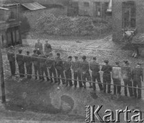 1945-1946, Lys-lez-Lannoy, Francja.
Żołnierze z 2. Dywizji Strzelców Pieszych stoją w szeregu przed swoim dowódcą. Za ich plecami rozwieszona jest siatka do gry w piłkę siatkową. Przy budynku stoją konie zaprzęgnięte do wozu.
Fot. Jerzy Konrad Maciejewski, zbiory Ośrodka KARTA
