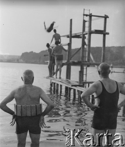 1942-1943, Moosseedorf, Szwajcaria.
Mężczyźni przyglądają się z brzegu żołnierzom z 2. Dywizji Strzelców Pieszych skaczącym do wody z pomostu.
Fot. Jerzy Konrad Maciejewski, zbiory Ośrodka KARTA
 
