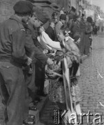 3.05.1946, Lille, Francja.
Rocznica uchwalenia Konstytucji 3 maja. Dziewczynki w strojach ludowych wpinają kwiaty w mundury polskich żołnierzy.
Fot. Jerzy Konrad Maciejewski, zbiory Ośrodka KARTA