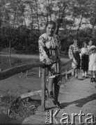 Po październiku 1939, Ocnita, Rumunia.
Młoda Rumunka w stroju ludowym pozuje do zdjęcia opierając się o balustradę mostu. 
Fot. Jerzy Konrad Maciejewski, zbiory Ośrodka KARTA
