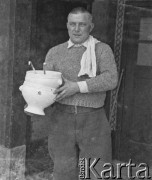 1940-1941, Münchenbuchsee, Szwajcaria.
Mężczyzna trzyma w ręku dwie puste wazy do zupy. 
Fot. Jerzy Konrad Maciejewski, zbiory Ośrodka KARTA