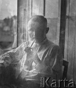 Zima 1940-1941, Münchenbuchsee, Szwajcaria.
Sierż. Jerzy Konrad Maciejewski z 2. Dywizji Strzelców Pieszych pali fajkę siedząc przy otwartym oknie. W czasie internowania wydawał z żołnierzami gazetę 